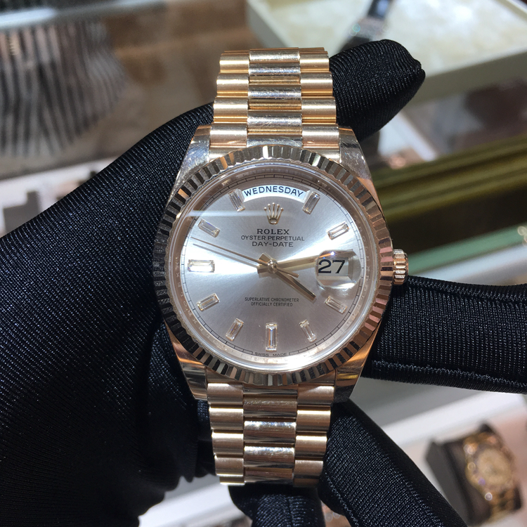 Rolex 劳力士 星期日历型系列，228235。40毫米表径，18K玫瑰金表壳，三角坑纹外圈，银灰色面盘，10颗方形切割钻石时标，3点位置为双重防反光小窗凸透镜放大日历，12点位置为星期显示，自产3255自动上弦机械机芯，专柜定价：328800元。 全套附件齐全。