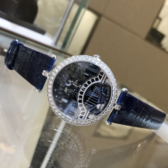 Van Cleef & Arpels 梵克雅宝 诗意复杂功能腕表系列， VCARN9VI00。梵克雅宝恋人之桥腕表的技术和创意名动一方，在表盘中，男孩显示分钟，女孩显示小时，表盘成为一对恋人的相遇地点，在每天23：55的时候女孩终于轻轻一跃，扑到男孩怀中，深情拥吻5分钟，这款腕表堪称机械与爱情的完美结合。 未使用品全套附件齐全。