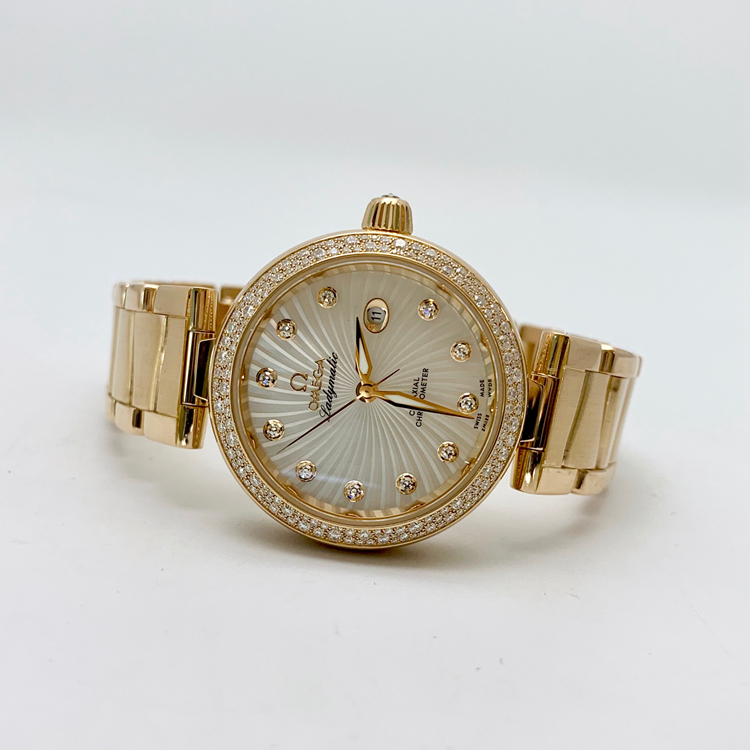 Omega 欧米茄 碟飞系列，425.65.34.20.55.003。34毫米表径，18K玫瑰金原钻表壳，刻钻珍珠贝母面盘，日期显示功能，自产Cal.8521自动上弦机械机芯，动力储备50小时。专柜定价：313100元。 单表无附件。