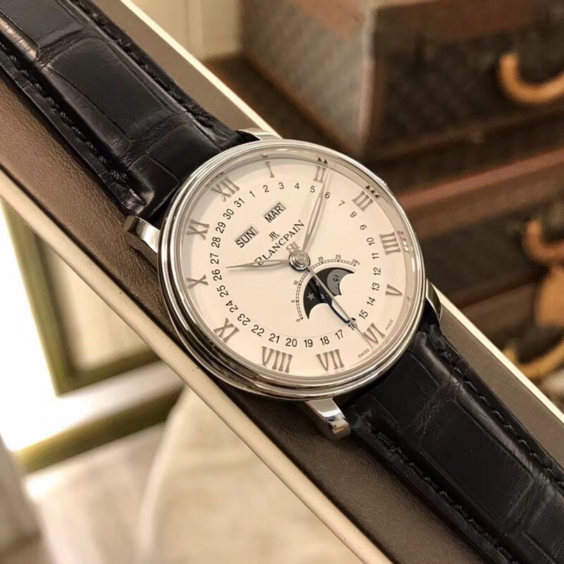 Blancpain 宝珀 Villeret 经典系列，6654-1127-55B，精钢表壳，40毫米表径，白色面盘，罗马数字时标，6点位置月相显示，12点位置为星期、月份显示。Cal.6654 自动上弦机芯，动力储备72小时。专柜售价：115500元。 单表附保卡。