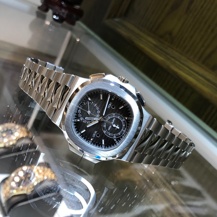 PATEK PHILIPPE 百达翡丽  NAUTILUS 运动系列，旅行家计时码表 5990/1A-001。40.5毫米表径，精钢表壳，黑色表盘带有从内到外的明暗渐变效果，搭配熟悉的NAUTILUS水平浮雕图案，并点缀10枚18K白金荧光立体时标，6点位置为60分钟累积计时器，12点位置为针式日期显示，两个独立昼/夜显示窗口，分别标示“LOCAL（当地）”和HOME（原居地）“，以显示不同时区的昼夜时间，有了这项功能，出门在外的人就不会在深夜无意间电话影响正在远方休息的家人。走遍全球，但始终不忘本源（家）。自产CH 28-520 C FUS自动上弦机械机芯，动力储备45-55小时。专柜定价：401400元。 全套附件齐全。