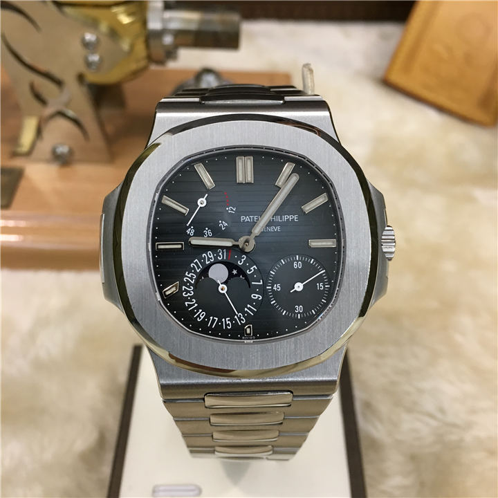 PATEK PHILIPPE 百达翡丽 运动系列，5712/1A。41毫米表径，精钢表壳。表盘中央的深蓝色向外渐变为黑色，带水平压纹图案，10个18K白金棒式时标，带荧光涂层。4点位置小秒针，7点位置日期、月相显示，9点位置动力储备显示。自动上弦机械机芯。双P印记，动力储备48小时。 全套附件齐全。