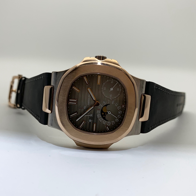 PATEK PHILIPPE 百达翡丽 NAUTILUS 运动系列，5712GR-001。40毫米表径，18K玫瑰金/18K白金表壳，10个18K玫瑰金棒式时标，18K玫瑰金棒式时针分针，白色涂漆18K黄金秒针、指针式日期显示、动力储备显示、月相显示功能，Cal.240 PS IRM C LU自动上弦机械机芯，动力储备48小时。专柜定价：339900元。 全套附件齐全。