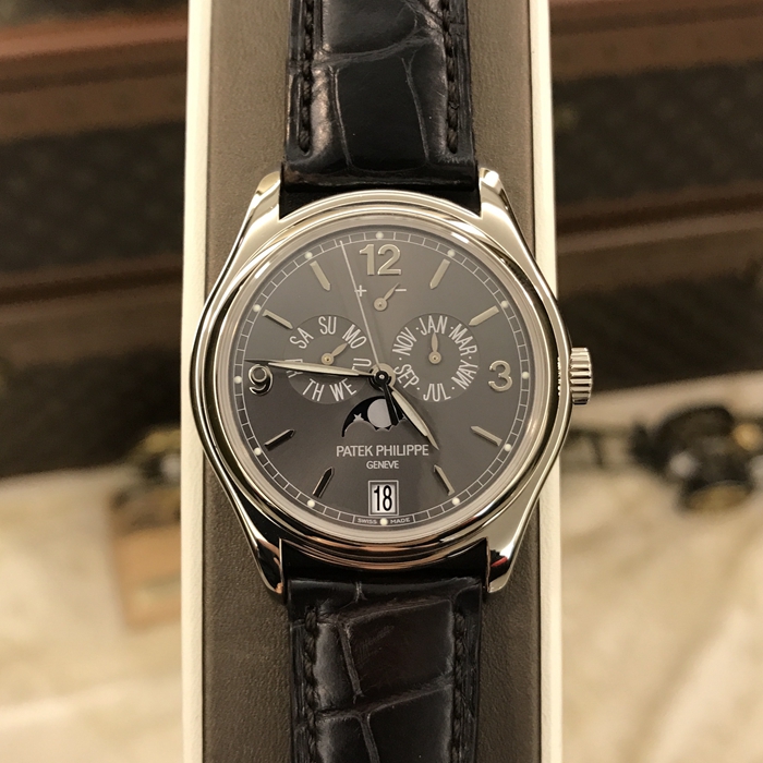 PATEK PHILIPPE 百达翡丽 复杂功能时计系列，5146G-010。39毫米表径，18K白金表壳。深灰色表盘，金质立体时标和字块，中心大秒针。年历功能，指针式星期和月份显示、动力储存显示，视窗式日期显示、月相显示。自产 324 S IRM QA LU 自动上弦机械机芯，动力储备35小时-45小时。双P印记。蓝宝石水晶透盖，折叠式表扣。专柜定价：296000元。 单表无附件。