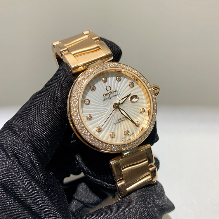 Omega 欧米茄 碟飞系列，425.65.34.20.55.003。34毫米表径，18K玫瑰金原钻表壳，刻钻珍珠贝母面盘，日期显示功能，自产Cal.8521自动上弦机械机芯，动力储备50小时。专柜定价：313100元。 单表无附件。