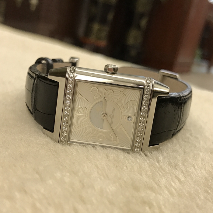 Jaeger-LeCoultre 积家 Reservo 翻转腕表系列，Q7058420。42x28.8毫米表径，精钢表壳镶嵌36颗钻石，约0.58克拉，银色正面表盘，扭索形及阳光形饰纹，6点位置日期显示，黑色背面表盘，配备外露摆陀。自动上弦机械机芯，动力储备42小时。 单表无附件。