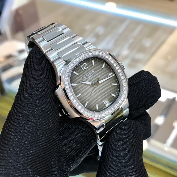 PATEK PHILIPPE 百达翡丽 NAUTILUS 运动系列，7018/1A-011。33.6毫米表径，精钢表壳，镶嵌50颗钻石，约0.71克拉，炭灰色饰有水平横纹浮雕图案面盘，金质立体字块，荧光时标，中心大秒针，6点位置视窗式日期显示，Cal.324 S C自动上弦机械机芯，动力储备45小时。专柜定价：247700元。 未使用品单表附保卡。
