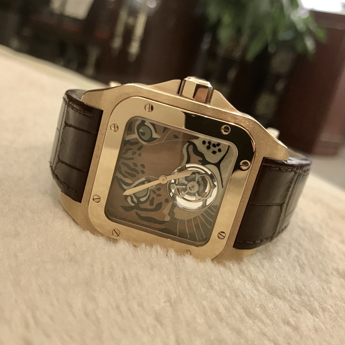 Cartier 卡地亚 桑托斯系列，HPI00328。54.9毫米表径，18K玫瑰金表壳。 雕刻木头拼接老虎面盘，6点位置陀飞轮装置。蓝宝石水晶玻璃表镜。手动上弦机械机芯，动力储备50小时。 单表无附件。