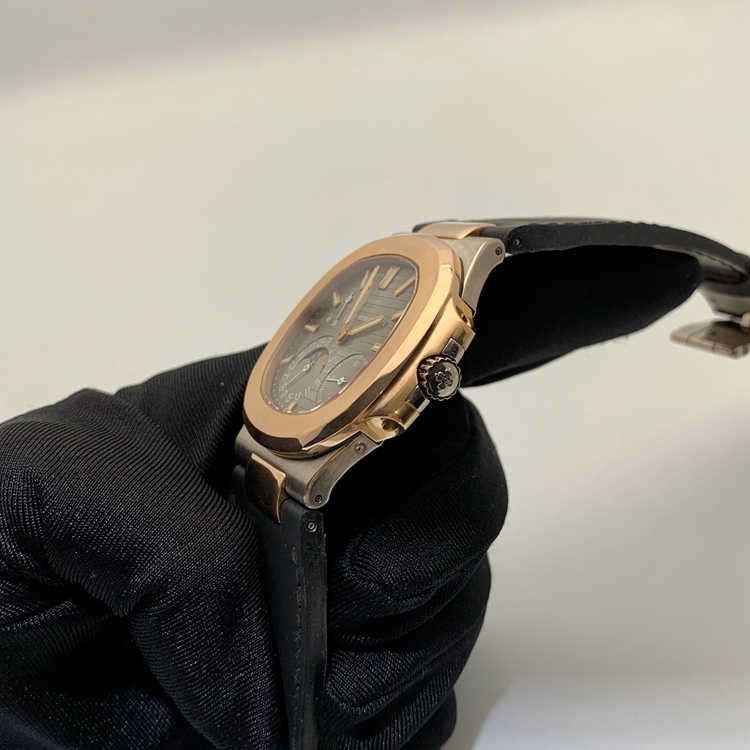 PATEK PHILIPPE 百达翡丽 NAUTILUS 运动系列，5712GR-001。40毫米表径，18K玫瑰金/18K白金表壳，10个18K玫瑰金棒式时标，18K玫瑰金棒式时针分针，白色涂漆18K黄金秒针、指针式日期显示、动力储备显示、月相显示功能，Cal.240 PS IRM C LU自动上弦机械机芯，动力储备48小时。专柜定价：339900元。 全套附件齐全。