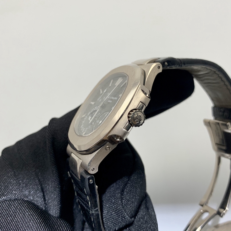PATEK PHILIPPE 百达翡丽 NAUTILUS 运动系列，5712G-001。40毫米表径，18K白金表壳，深灰色面盘，覆荧光涂层金质立体时标，指针式日期显示、月相显示、动力储备显示功能，Cal.240 PS IRM C LU自动上弦机械机芯，动力储备48小时。专柜定价：318800元。 全套附件齐全。