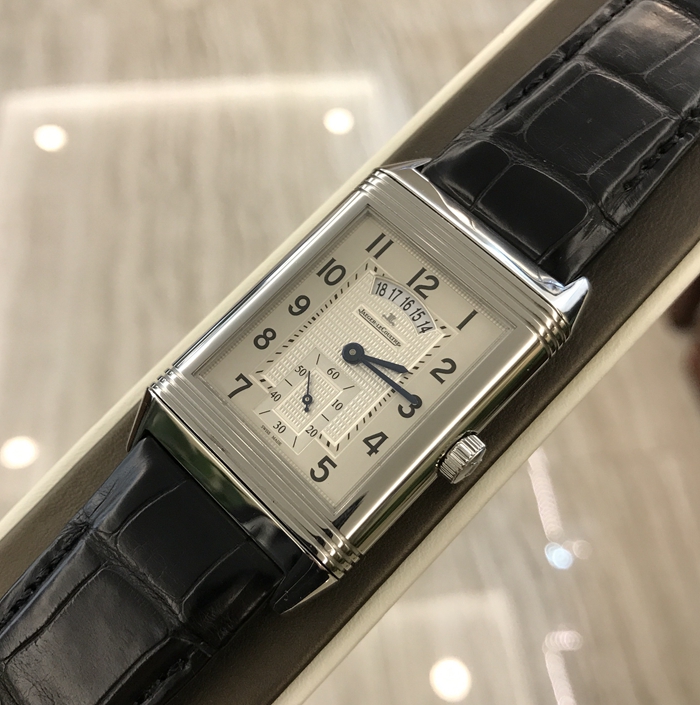 Jaeger-LeCoultre 积家 Reservo 翻转腕表系列，Q3748421。48.5x29.5毫米表径，精钢表壳，两个表盘分别显示两个不同的时间。正面显示标准时间，并设有小秒针于6点位置和12点位设日期窗口，表盘外侧饰以垂直雕纹、中间以巴黎钉饰纹修饰。背面显示第二时区时间，并设有昼／夜指示功能。手动上弦机械机芯，动力储备48小时。专柜定价：72500元。 单表无附件。