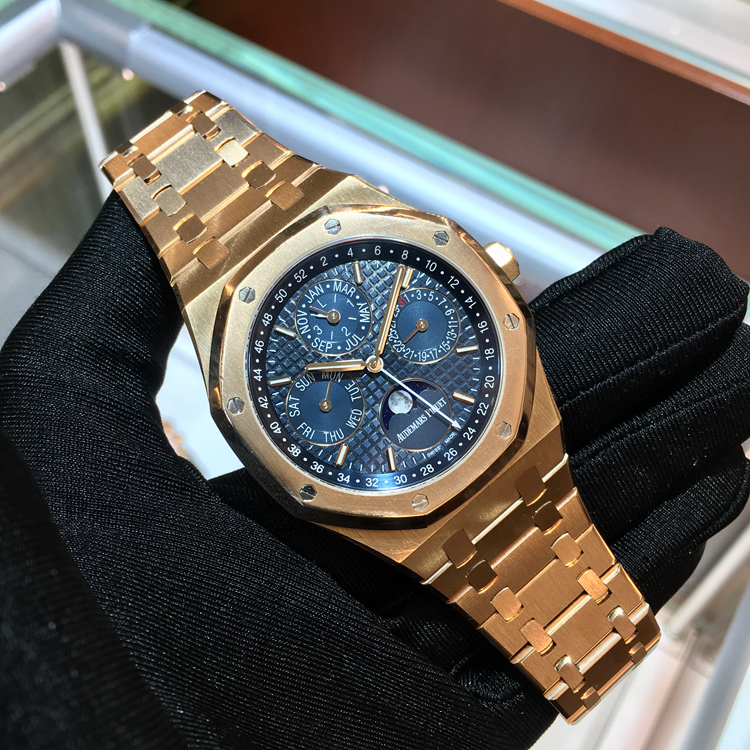 Audermars Piguet 爱彼 皇家橡树系列，26574OR.OO.1220OR.02。41毫米表径，18K玫瑰金表壳，蓝色面盘，镌刻“ Grande Tapisserie大格纹装饰图案， 荧光玫瑰金嵌入式时标和荧光皇家橡树指针，蓝色内表圈。搭配万年历、星期、日期、天文精确月相、月份、闰年、小时及分钟显示功能，自产5134自动上弦机械机芯，动力储备40小时，专柜定价：716000元。 单表无附件。