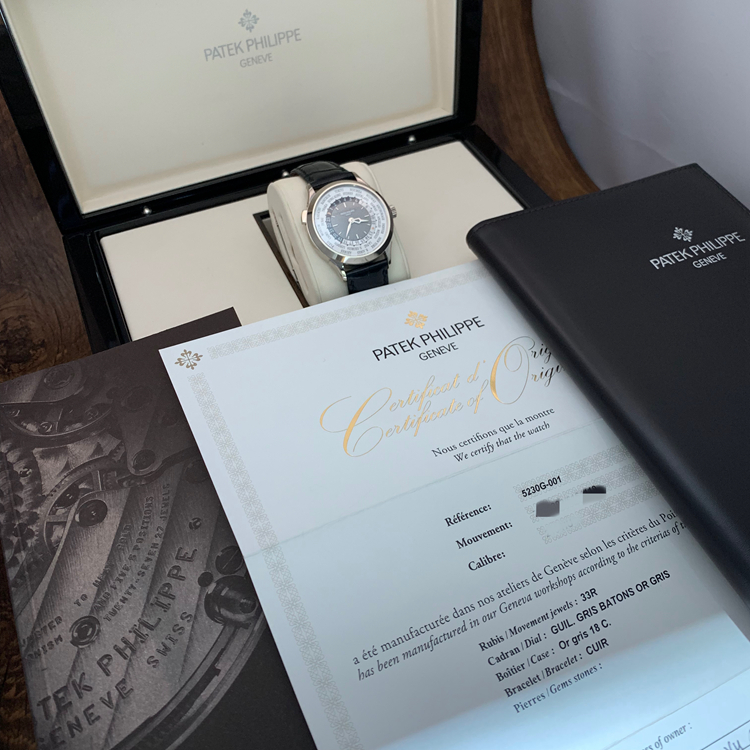 PATEK PHILIPPE 百达翡丽 复杂功能时计系列，5230G-001。38.5毫米表径，18K白金表壳，炭灰色漆表盘，手工雕饰纹，金质立体时标，24个时区的24小时与昼/夜显示，240 HU自动上弦机械机芯，动力储备48小时，专柜定价：348600元。 全套附件齐全。