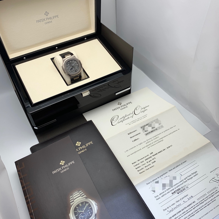 PATEK PHILIPPE 百达翡丽 NAUTILUS 运动系列，5712G-001。40毫米表径，18K白金表壳，深灰色面盘，覆荧光涂层金质立体时标，指针式日期显示、月相显示、动力储备显示功能，Cal.240 PS IRM C LU自动上弦机械机芯，动力储备48小时。专柜定价：318800元。 全套附件齐全。