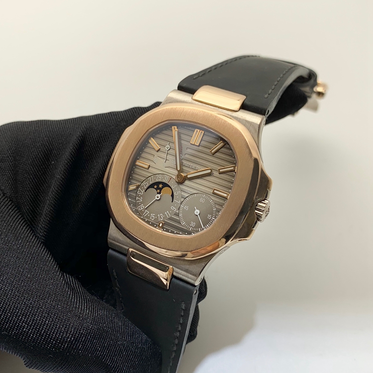 PATEK PHILIPPE 百达翡丽 NAUTILUS 运动系列，5712GR-001。40毫米表径，18K玫瑰金/18K白金表壳，10个18K玫瑰金棒式时标，18K玫瑰金棒式时针分针，白色涂漆18K黄金秒针、指针式日期显示、动力储备显示、月相显示功能，Cal.240 PS IRM C LU自动上弦机械机芯，动力储备48小时。专柜定价：339900元。 全套附件齐全。