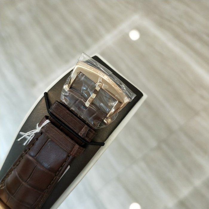 RogerDubuis 罗杰杜彼 Hommage 致敬系列，RDDBHO0569。42毫米表径。18K玫瑰金表壳， 手工玑镂饰纹表盘，腕表采用造型大胆的长方形按把和布满凹槽线条的表冠，展现出鲜明的阳刚性格，却又以优美的圆弧曲线以及长秒针的叶形尾端带来柔和的色彩。位于3点钟和9点钟位置的蜗形纹计时圈有力地见证着传统制表同样能够符合现代精确计时需求的事实。蓝宝石水晶玻璃表镜。RD680 自动上弦机械机芯，搭载微型摆陀。动力储备52小时。 全套附件齐全。