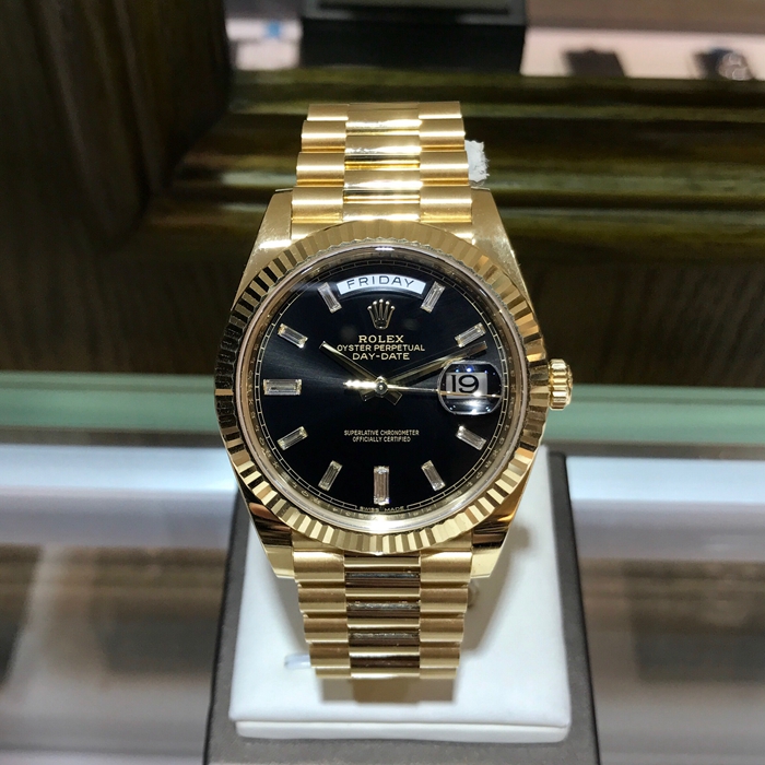 Rolex 劳力士 星期日历型系列，228238。40毫米表径，18K黄金表壳，黑色面盘镶嵌10颗梯方钻石 ，中央时、分及秒针；快调瞬跳星期日历；秒针暂停功能以准确调校时间。抗刮损蓝水晶，防反光凸透式放大日历窗，自产3255型自动上弦机械机芯，动力储备70小时。专柜定价：258000元。 单表无附件。