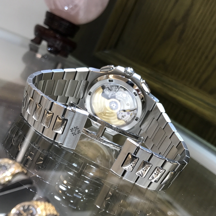 PATEK PHILIPPE 百达翡丽  NAUTILUS 运动系列，旅行家计时码表 5990/1A-001。40.5毫米表径，精钢表壳，黑色表盘带有从内到外的明暗渐变效果，搭配熟悉的NAUTILUS水平浮雕图案，并点缀10枚18K白金荧光立体时标，6点位置为60分钟累积计时器，12点位置为针式日期显示，两个独立昼/夜显示窗口，分别标示“LOCAL（当地）”和HOME（原居地）“，以显示不同时区的昼夜时间，有了这项功能，出门在外的人就不会在深夜无意间电话影响正在远方休息的家人。走遍全球，但始终不忘本源（家）。自产CH 28-520 C FUS自动上弦机械机芯，动力储备45-55小时。专柜定价：401400元。 全套附件齐全。
