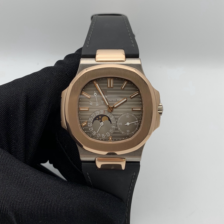 PATEK PHILIPPE 百达翡丽 NAUTILUS 运动系列，5712GR-001。40毫米表径，18K玫瑰金/18K白金表壳，10个18K玫瑰金棒式时标，18K玫瑰金棒式时针分针，白色涂漆18K黄金秒针、指针式日期显示、动力储备显示、月相显示功能，Cal.240 PS IRM C LU自动上弦机械机芯，动力储备48小时。专柜定价：339900元。 全套附件齐全。