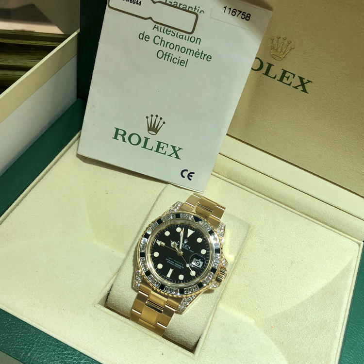 Rolex 劳力士 格林尼治型II系列，116758。40毫米表径，18k黄金镶钻黑色蓝宝石，表圈共镶嵌36颗钻石和黑色蓝宝石12颗，黑色面盘，3点位置日期显示，自产3186自动上弦机械机芯。专柜定价：965200元。 全套附件齐全。