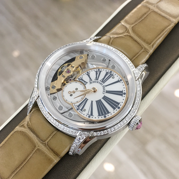 Audemars Piguet 爱彼 Millenary千禧系列，77247BC.ZZ.A813CR.01，39.5*35.5毫米表径。手动上链腕表，搭配小秒针。18K白金表壳搭配镶钻表圈和表耳及镶嵌一颗粉红色凸面蓝宝石的表冠，116颗明亮型切割美钻，总重约0.60克拉（表圈和表耳）。白色珍珠贝母偏心式圆盘，小秒盘，炭灰色印制罗马数字，玫瑰金指针。方形大鳞片米黄色鳄鱼皮表带。5201型手动上链自产机芯，动力储备54小时。专柜定价：230000元。