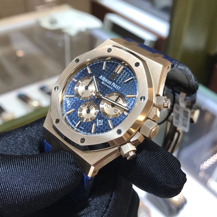 Audermars Piguet 爱彼 皇家橡树系列，26331OR.OO.D315CR.01。41毫米表径，18K玫瑰金表壳，蓝色面盘镌刻“Grande Tapisserie”大格纹装饰，玫瑰金色副表盘，搭配玫瑰金荧光立体时标和皇家橡树指针。日期显示、计时功能自动上弦机械机芯，动力储备40小时。专柜定价：287000元。 未使用品全套附件齐全。