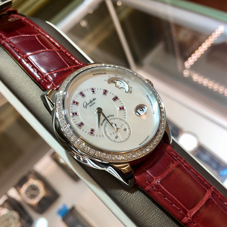 Glashutte 格拉苏蒂原创 女表90系列，1-90-12-05-30-01。精钢39.4毫米表径，原装镶钻，镶嵌 64 颗钻石(总重约 0.95ct，VVS), 表冠镶嵌红宝石 (约 0.022ct, VVS)。珍珠母贝白色表盘，18颗红宝石（约0.045克拉，VVS）。金质偏心盘指针，大日历显示，月相显示，自动上弦机械机芯，动力储备42小时，全球限量50枚。专柜定价：154000元。 未使用品全套附件齐全。