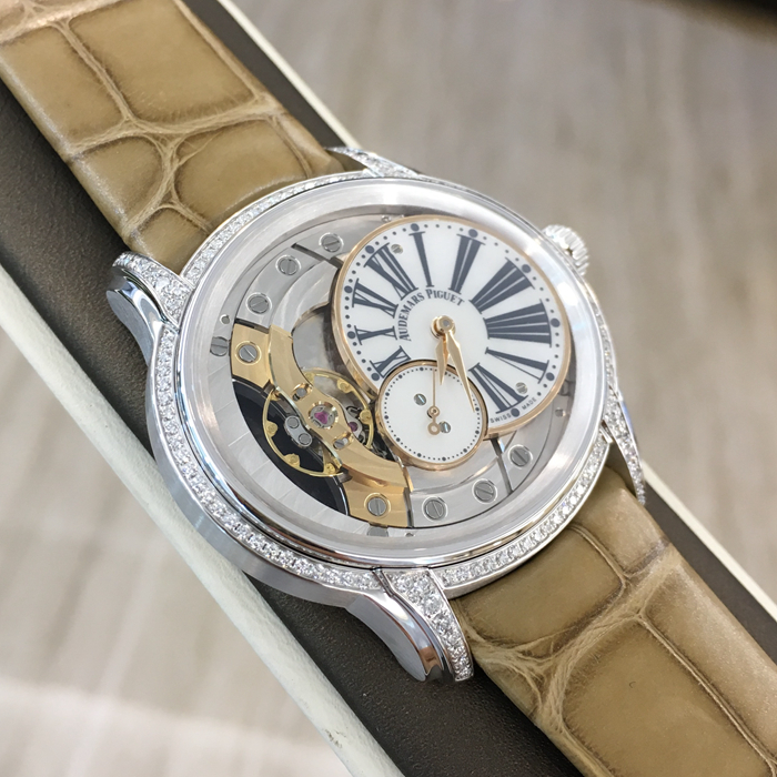 Audemars Piguet 爱彼 Millenary千禧系列，77247BC.ZZ.A813CR.01，39.5*35.5毫米表径。手动上链腕表，搭配小秒针。18K白金表壳搭配镶钻表圈和表耳及镶嵌一颗粉红色凸面蓝宝石的表冠，116颗明亮型切割美钻，总重约0.60克拉（表圈和表耳）。白色珍珠贝母偏心式圆盘，小秒盘，炭灰色印制罗马数字，玫瑰金指针。方形大鳞片米黄色鳄鱼皮表带。5201型手动上链自产机芯，动力储备54小时。专柜定价：230000元。