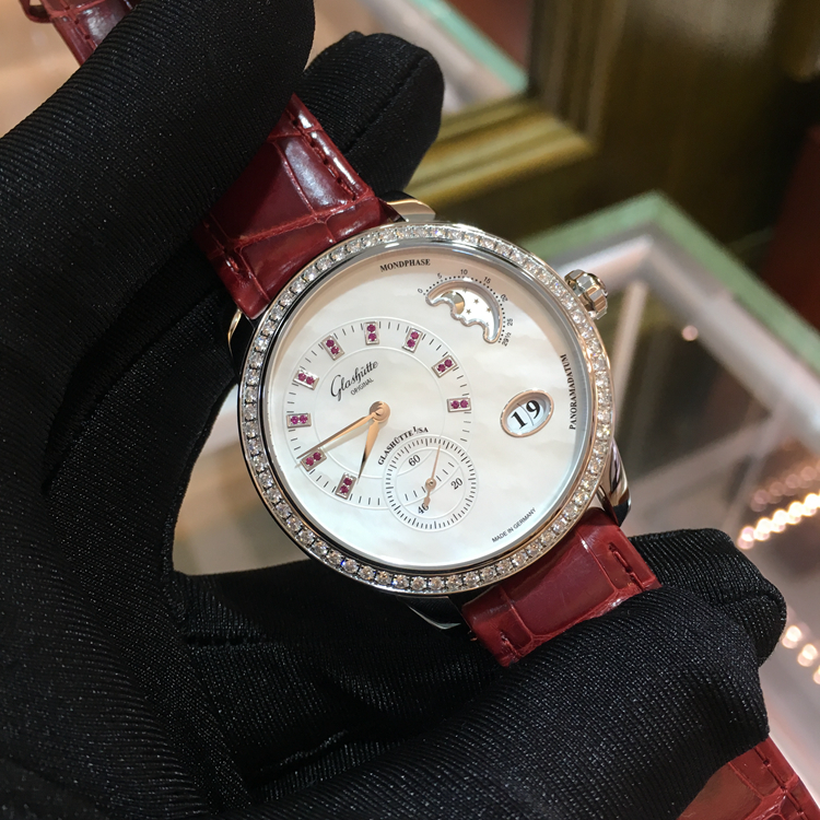 Glashutte 格拉苏蒂原创 女表90系列，1-90-12-05-30-01。精钢39.4毫米表径，原装镶钻，镶嵌 64 颗钻石(总重约 0.95ct，VVS), 表冠镶嵌红宝石 (约 0.022ct, VVS)。珍珠母贝白色表盘，18颗红宝石（约0.045克拉，VVS）。金质偏心盘指针，大日历显示，月相显示，自动上弦机械机芯，动力储备42小时，全球限量50枚。专柜定价：154000元。 未使用品全套附件齐全。