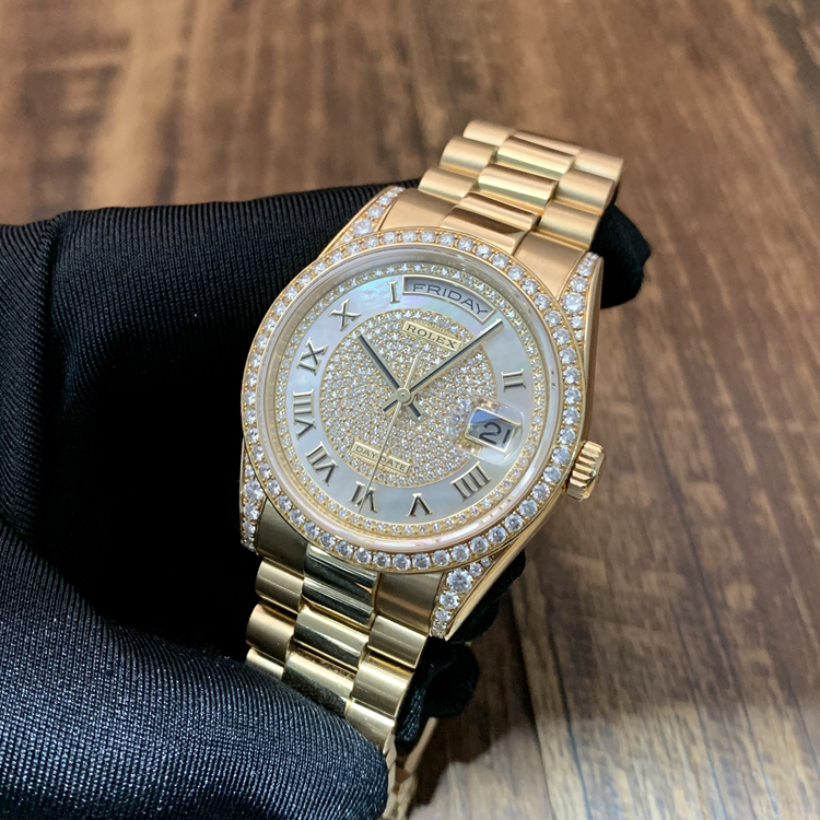 Rolex 劳力士 星期日历型系列，m118388-0030。36毫米表径，18K黄金原钻表壳，珍珠母贝密镶钻石面盘，罗马数字时标，中央时、分及秒针；快调瞬跳星期日历；3点位置为防反光凸透式放大日历窗，12点位置为星期显示，3155自动上弦机械机芯。 全套附件齐全。