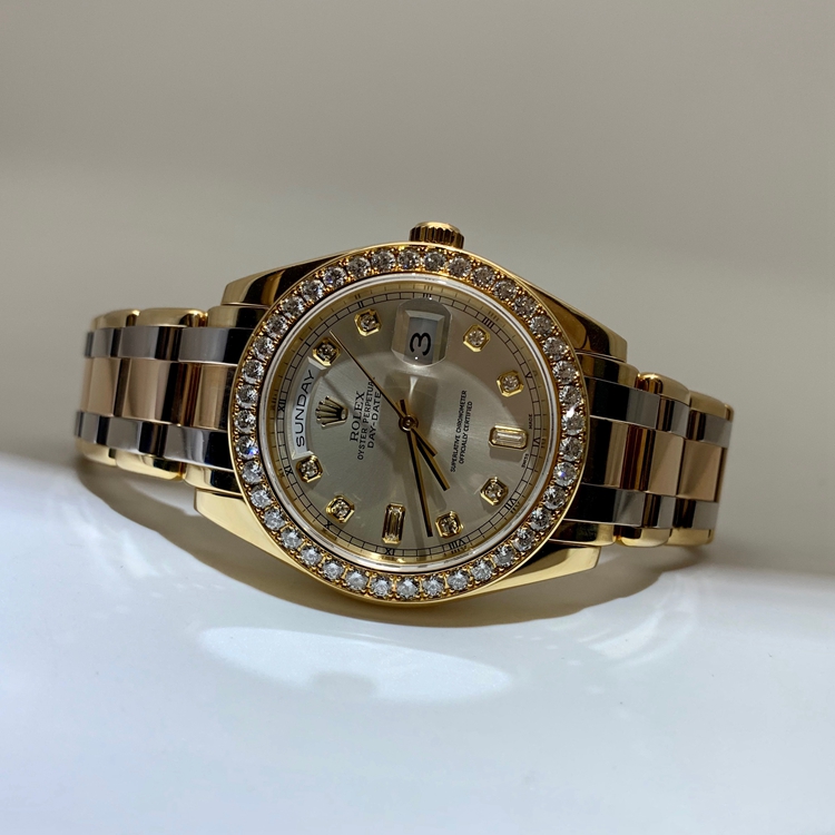 Rolex 劳力士 星期日历型系列，18948-72748TRIDOR-8R2B。39毫米表径，18K黄金/18K玫瑰金/18k白金原钻表壳，银白色面盘，钻石时标，中央时、分及秒针；快调瞬跳星期日历；3点位置为防反光凸透式放大日历窗，12点位置为星期显示，自动上弦机械机芯。 单表无附件。