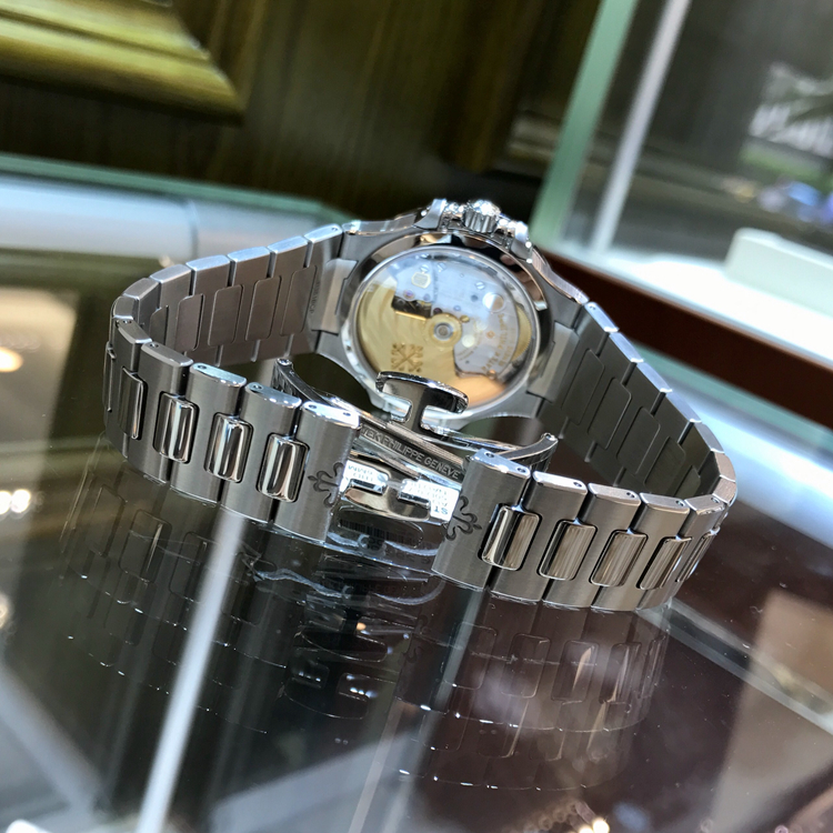 PATEK PHILIPPE 百达翡丽 NAUTILUS 运动系列，7018/1A-011。33.6毫米表径，精钢表壳，镶嵌50颗钻石，约0.71克拉，炭灰色饰有水平横纹浮雕图案面盘，金质立体字块，荧光时标，中心大秒针，6点位置视窗式日期显示，Cal.324 S C自动上弦机械机芯，动力储备45小时。专柜定价：247700元。 未使用品单表附保卡。