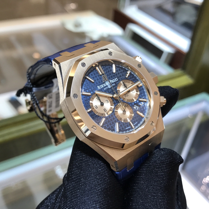 Audermars Piguet 爱彼 皇家橡树系列，26331OR.OO.D315CR.01。41毫米表径，18K玫瑰金表壳，蓝色面盘镌刻“Grande Tapisserie”大格纹装饰，玫瑰金色副表盘，搭配玫瑰金荧光立体时标和皇家橡树指针。日期显示、计时功能自动上弦机械机芯，动力储备40小时。专柜定价：287000元。 未使用品全套附件齐全。