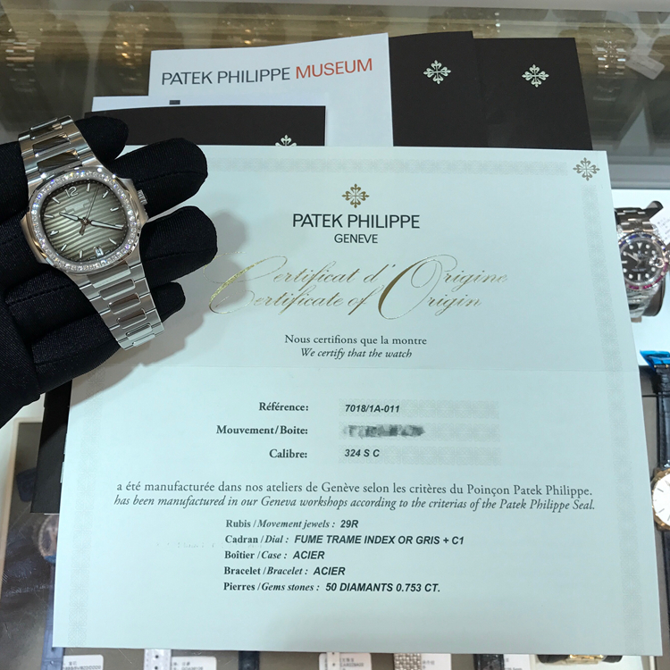 PATEK PHILIPPE 百达翡丽 NAUTILUS 运动系列，7018/1A-011。33.6毫米表径，精钢表壳，镶嵌50颗钻石，约0.71克拉，炭灰色饰有水平横纹浮雕图案面盘，金质立体字块，荧光时标，中心大秒针，6点位置视窗式日期显示，Cal.324 S C自动上弦机械机芯，动力储备45小时。专柜定价：247700元。 未使用品单表附保卡。