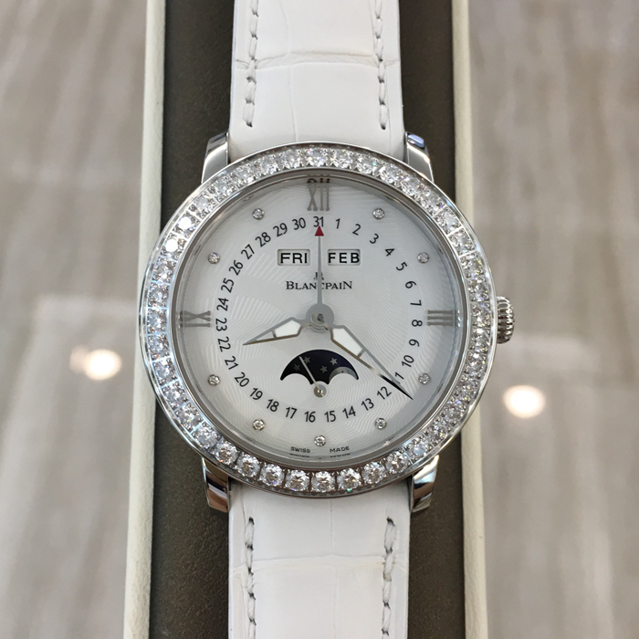 Blancpain 宝珀 WOMEN 女装系列，3663A-4654-55B。35毫米表径，精钢材质，透明表底，表圈镶嵌40壳明亮式钻石，约1.95克拉。珍珠贝母面镶嵌美钻，中心指针式日期显示，视窗式月份、星期、月相显示，六时位小秒针。自产 Cal.6763 自动上弦机械机芯，动力储备100小时。专柜定价148500元。 未使用品全套附件齐全。