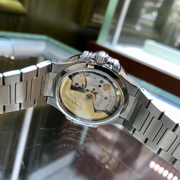 PATEK PHILIPPE 百达翡丽 NAUTILUS 运动系列，7018/1A-011。33.6毫米表径，精钢表壳，镶嵌50颗钻石，约0.71克拉，炭灰色饰有水平横纹浮雕图案面盘，金质立体字块，荧光时标，中心大秒针，6点位置视窗式日期显示，Cal.324 S C自动上弦机械机芯，动力储备45小时。专柜定价：247700元。 未使用品单表附保卡。